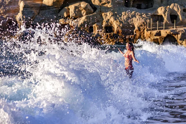 Uma onda alta na praia de Matala na ilha de Creta atinge uma garota de biquíni — Fotografia de Stock