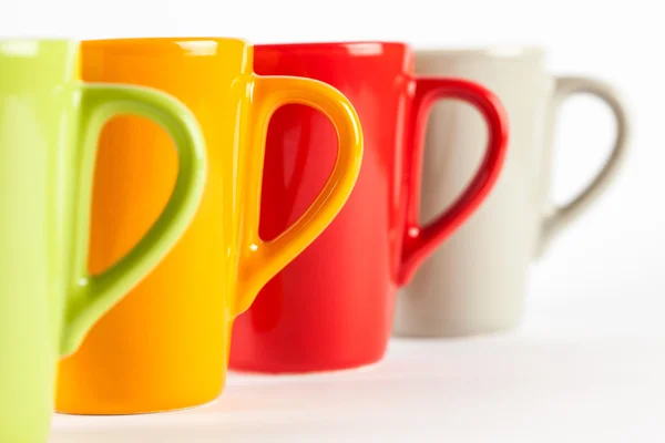 Quatro copos de chá de cor mostrados em linha — Fotografia de Stock