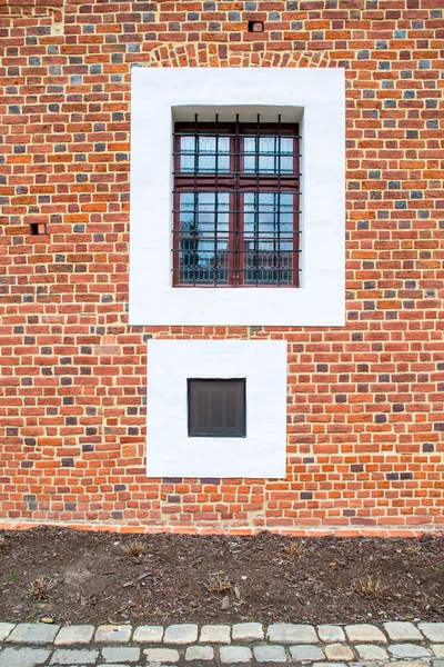 Two old square windows, one with steel grating — Stock Photo, Image