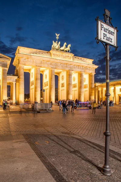 Berlim - Alemanha - 29 de setembro As pessoas caminham em Pariser Platz. Quadriga localizado no topo do Portão de Brandemburgo, em Berlim, Bermany. Imagem noturna da Quadriga com céu escuro e negro . — Fotografia de Stock