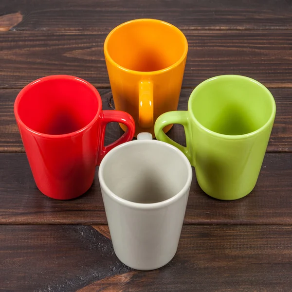 Quattro tazze da tè vuote di colore disposte in una croce — Foto Stock