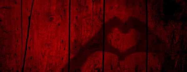 Concept or conceptual Valentine human man and woman hands silhouette as heart or love symbol on old red wood background — Stock Photo, Image