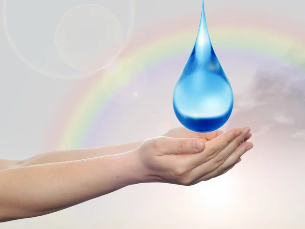 개념 또는 개념적 푸른 물 또는 액체 방울 레인 보우 하늘 배경에 두 여자 손에 떨어지는 — 스톡 사진