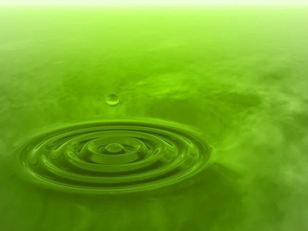 green liquid drop falling in water