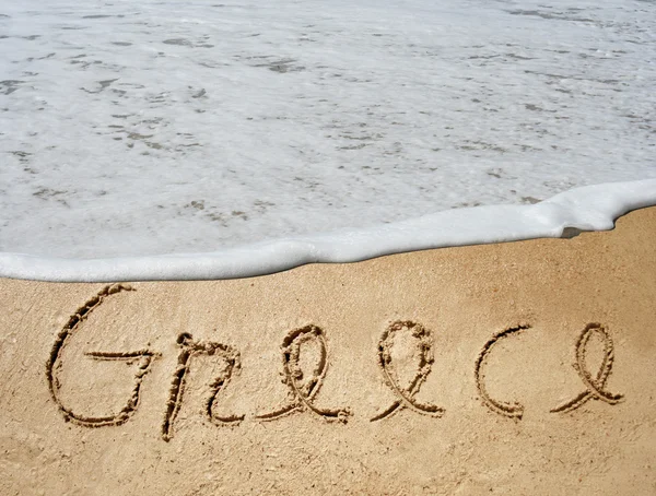 Grécia texto em areia em uma praia — Fotografia de Stock