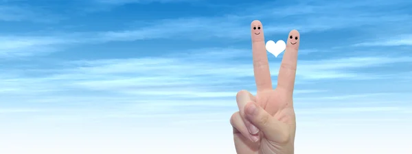 Concept or conceptual human or female hands with two fingers painted with a red heart and smiley faces over cloud blue sky background banner — Stock Photo, Image