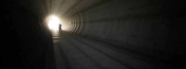 Concept or conceptual dark tunnel with a bright light at the end or exit as metaphor to success, faith, future or hope, a black silhouette of walking man to new opportunity or freedom 3d illustration