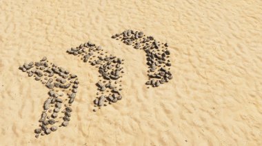 Kumsalda el yapımı sembol şeklinde kavramsal taşlar, altın kumlu arka plan, tehlikeli yol işareti. Dikkat, uyarı, güvenlik ve rehberlik için 3D illüstrasyon metaforu