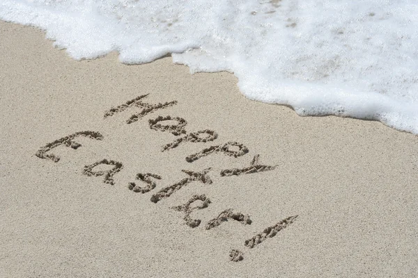 Handgeschriebener fröhlicher Ostertext in Sand — Stockfoto