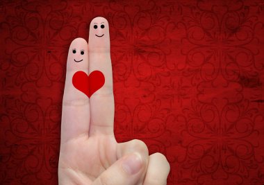 fingers with  heart painted over a red paper vintage and grungy pattern background