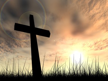 religion symbol silhouette in grass over a sunset or sunrise sky with sunlight clouds background