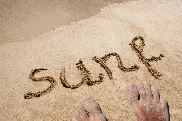 Słowo w piasku na plaży — Zdjęcie stockowe