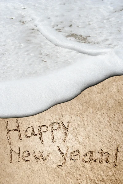 Concept or conceptual hand made or handwritten Happy new year text in sand on a beach in an exotic island — Stock Photo, Image