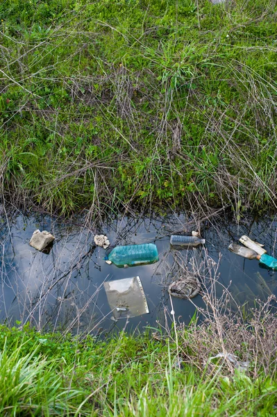 Concept or conceptual unhygienic polluted river,sewage or dirty water and grass with waste,trash and dump background — Stock Photo, Image