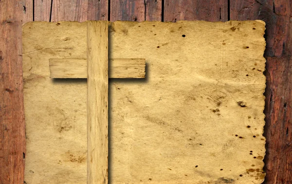 High resolution christian cross cut in an old grungy or vintage paper, over a wood background — ストック写真