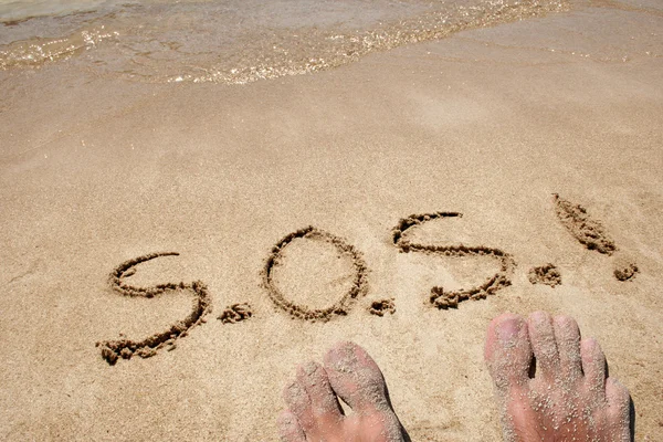 Concepto o S.O.S. conceptual texto escrito a mano en la arena en una playa en un fondo exótico isla —  Fotos de Stock