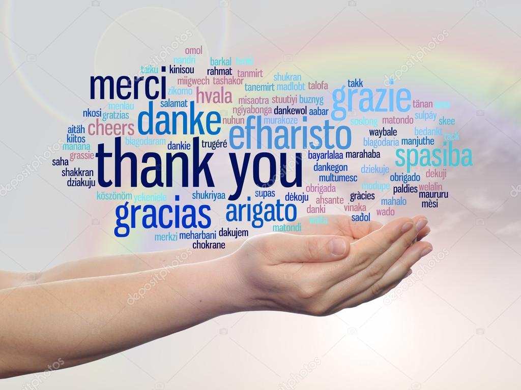 Concept or conceptual abstract thank you word cloud held in hands in different languages or multilingual for education or Thanksgiving Day over rainbow sky