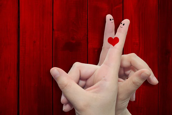 两只手的手指与红色木材图案复古背景中画了一颗心 — 图库照片