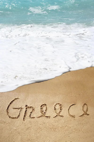 Griechischer Text im Sand am Strand — Stockfoto