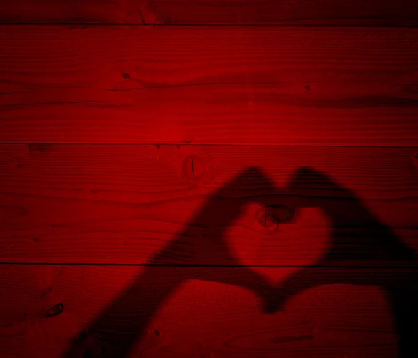 Conceito ou conceitual Valentim homem humano e mulher mãos silhueta como símbolo de coração ou amor no fundo de madeira vermelha velha — Fotografia de Stock