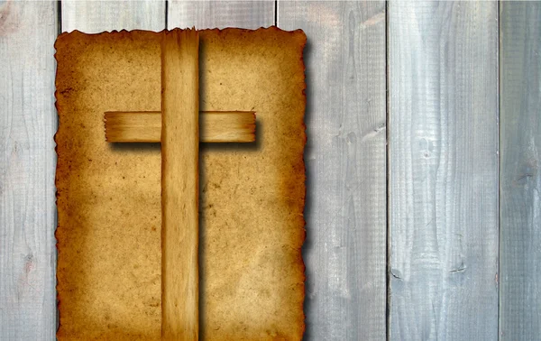 Conceptual Christian cross cut in an old grungy or vintage paper, over a wood — ストック写真