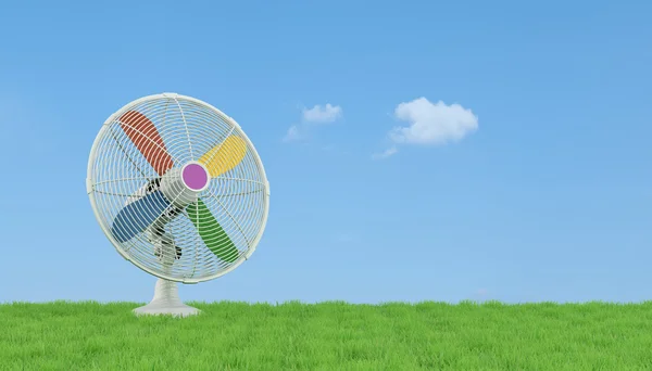 Colorful electric fan on grass — Stock Photo, Image