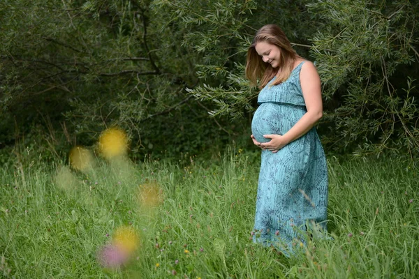 Young pregnant woman in meadow — Stock Photo, Image