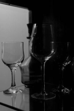 Şarap uzun cam bardaklar ve yeşil dekoratif eski içki şişesi cam ahşap vitrin.