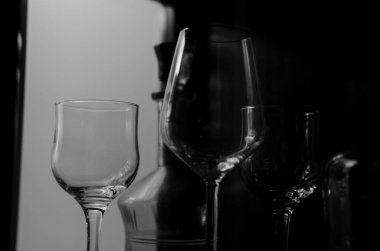 Şarap uzun cam bardaklar ve yeşil dekoratif eski içki şişesi cam ahşap vitrin.