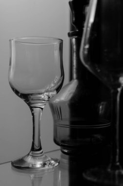 Şarap uzun cam bardaklar ve yeşil dekoratif eski içki şişesi cam ahşap vitrin.