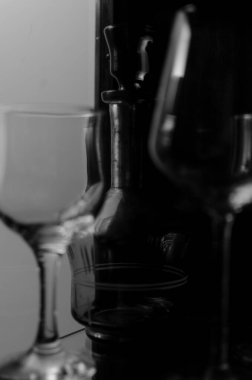 Şarap uzun cam bardaklar ve yeşil dekoratif eski içki şişesi cam ahşap vitrin.