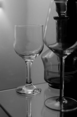 Şarap uzun cam bardaklar ve yeşil dekoratif eski içki şişesi cam ahşap vitrin.