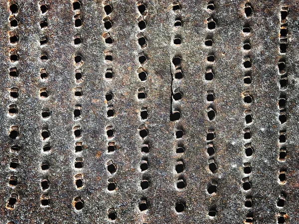 Old rusty iron sheet with holes as a background — Stock Photo, Image