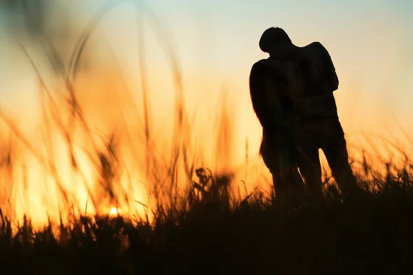 gün batımında öpüşme genç bir çift silüeti