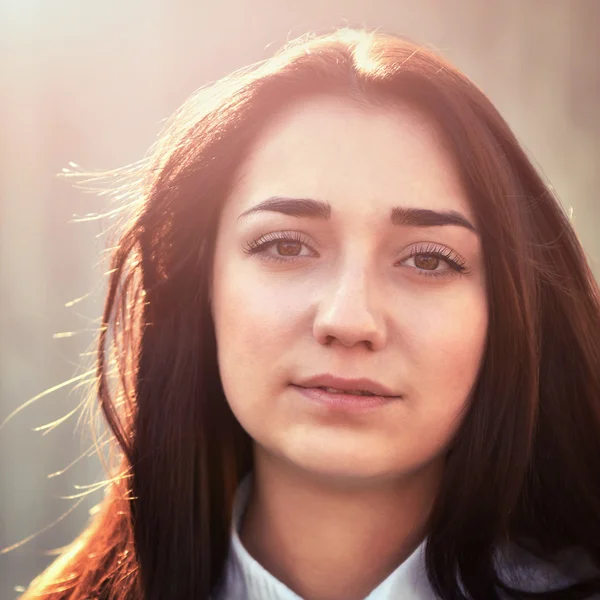 Portrait of a young pretty girl in a light shirt and with her ha — Stock Photo, Image