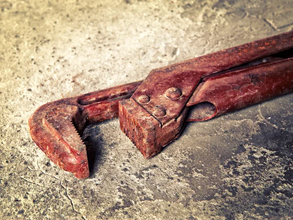 Old wrench on concrete closeup — Stock Photo, Image