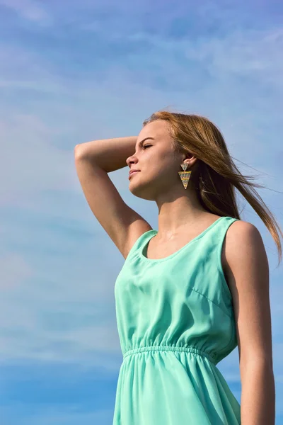 Молодая чувственная улыбающаяся блондинка позирует под ярким солнечным светом на открытом воздухе — стоковое фото