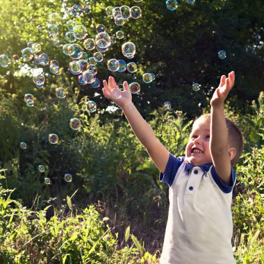Oynayan çocuk sabun köpüğü açık havada yakalamak