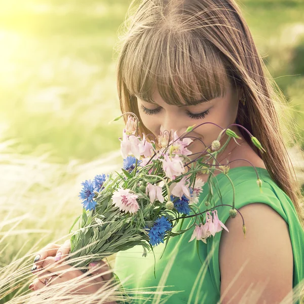 Young sensual girl smelling a bouquet of wildflowers — Stock Photo, Image