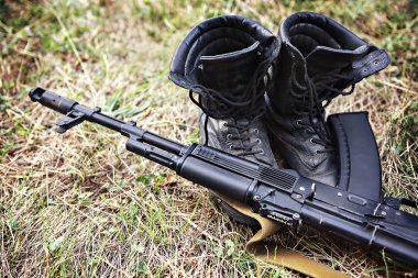 asker ayak bileği bot ve bir Kalaşnikof saldırı tüfeği yakın çekim