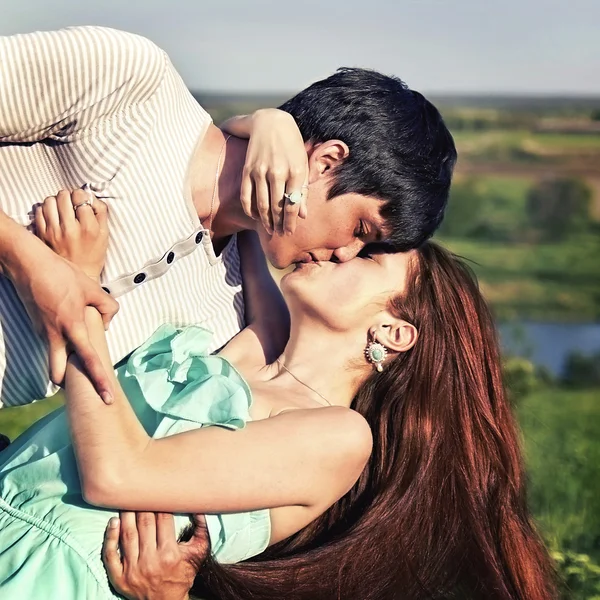 Летний портрет молодой пары, целующейся на открытом воздухе — стоковое фото