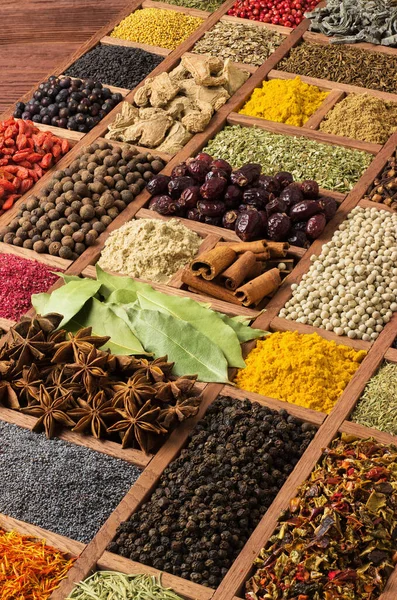 Baharatlar ve bitkiler. Dünyanın her yerinden lezzetler. Lezzetli yemekler pişirmek için renkli baharatlar. Tahta kutuda mevsimler.