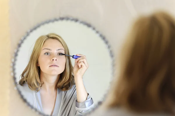 Beautiful young woman doing make-up — Stock Photo, Image