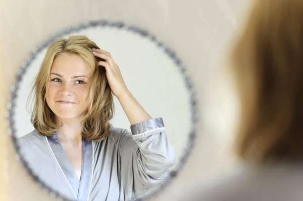 Belle jeune femme faisant des cheveux — Photo