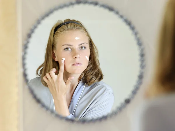 güzel bir genç kadın yüz kremini uygulamadan