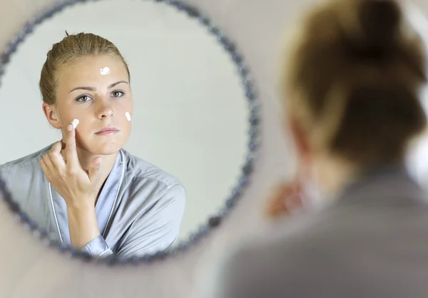 güzel bir genç kadın yüz kremini uygulamadan