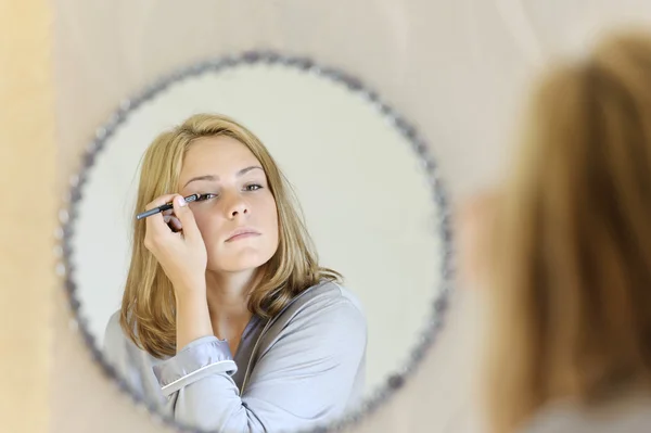 Piękna młoda kobieta robi makijaż — Zdjęcie stockowe