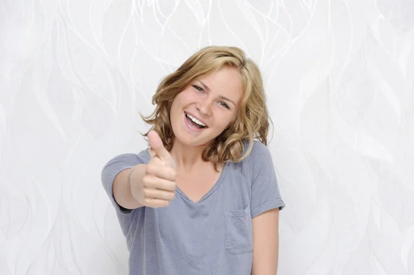 Young smiling woman showing thumbs up — Stock Photo, Image