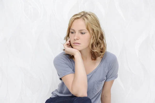 Mujer joven sentada pensativa —  Fotos de Stock