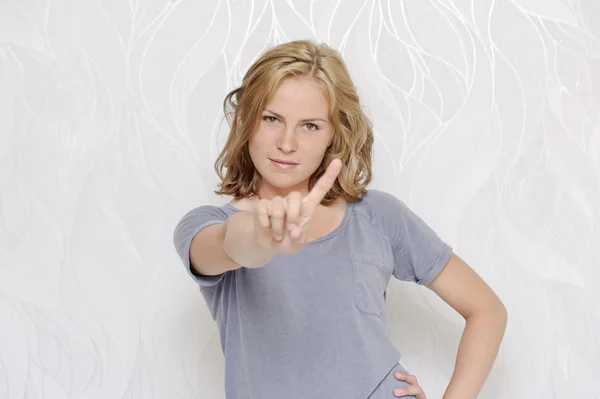 Junge Frau zeigt Zeigefinger — Stockfoto